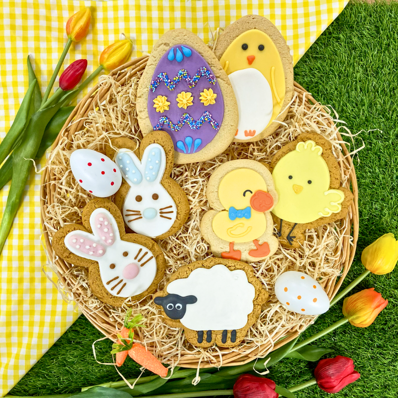 Hand iced biscuits placed in an Easter nest including eggs, chick, bunnies, duck and sheep.