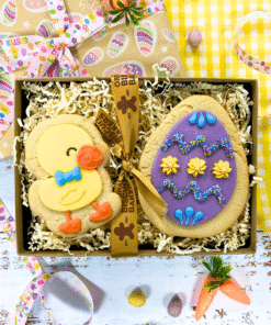 Hand-decorated sugar cookie duck and Easter egg biscuit duo in a ribbon tied gift box.