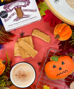 Billington's Gingerbread and an Original Biscuit Bakers pumpkin biscuit displayed in an autumn Halloween setting with a hot drink, seasonal pumpkins, autumn leaves, cobweb decorations and decorative spiders.