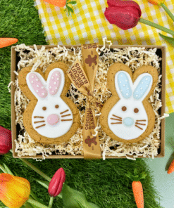 Easter gift box with two hand‑iced gingerbread bunny biscuits with pink and blue details, presented in a craft box with ribbon