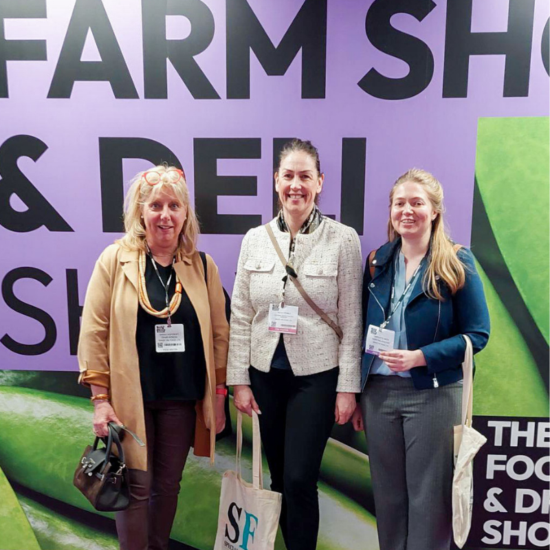 Original Biscuit Bakers colleagues at the Farm Shop & Deli Show, standing in front of exhibition signage.