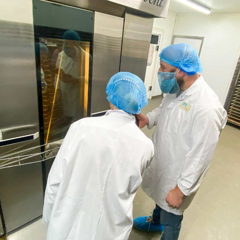 Managing Director Gemma Williams of Original Biscuit Bakers speaking with Adam Green from BBC Radio Shropshire while inspecting the bakery oven.