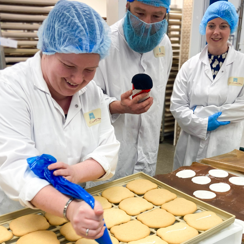 Decorator Beth demonstrating sugar pasting during a bakery visit at Original Biscuit Bakers.