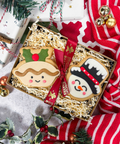Christmas biscuit gift box featuring hand-iced sugar cookie mince pie and snowman biscuits, presented with festive ribbon and seasonal Christmas decorations.